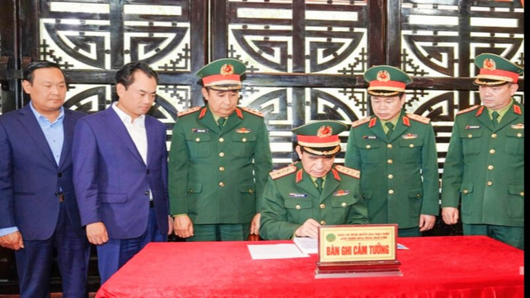 Đại tướng Phan Văn Giang ghi cảm tưởng vào Sổ vàng lưu niệm tại Nhà tưởng niệm Chủ tịch Hồ Chí Minh.