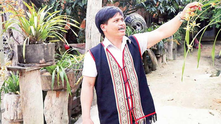 Chủ nhiệm HTX du lịch Vi Rơ Ngheo A Hiền giới thiệu về hoa lan ở làng du lịch.