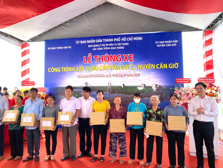 Lãnh đạo địa phương tặng quà cảm ơn bà con nhân dân tích cực giao mặt bằng để công trình cầu Vàm Sát 2 sớm được thi công hoàn tất.