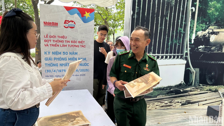 Khách tham quan hào hứng khi được cầm trên tay phụ san đặc biệt của Báo Nhân Dân. (Ảnh: HẢI YẾN) Khách tham quan hào hứng khi được cầm trên tay phụ san đặc biệt của Báo Nhân Dân. (Ảnh: HẢI YẾN)