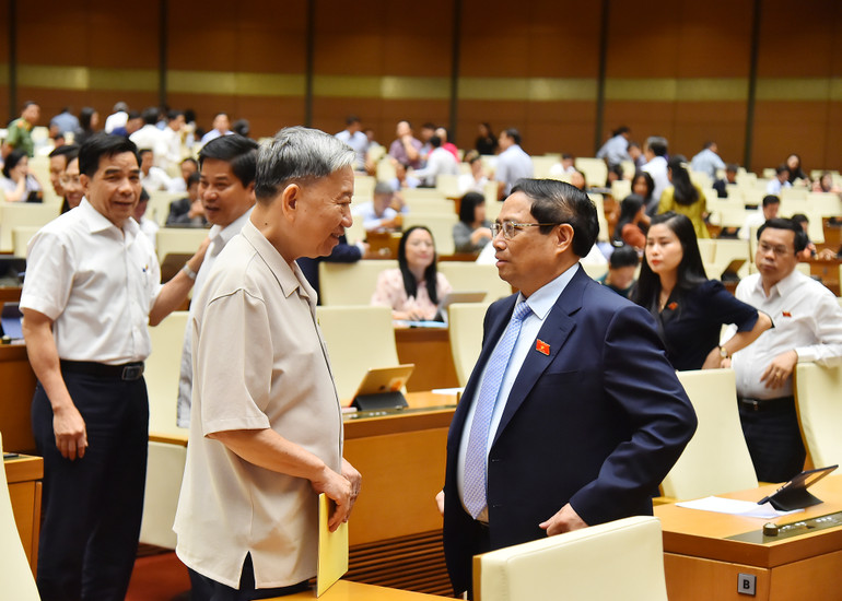 Thủ tướng Phạm Minh Chính và Bộ trưởng Công an Tô Lâm trao đổi bên lề phiên họp ngày 21/5.