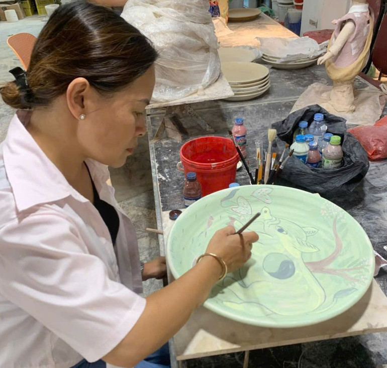 Họa sĩ Nguyễn Thị Thu Trang vẽ trên gốm.