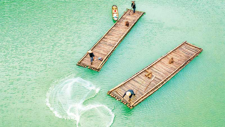 Ngư dân quăng chài trên hồ Thang Hen. (Ảnh ĐỖ TUẤN HÙNG)