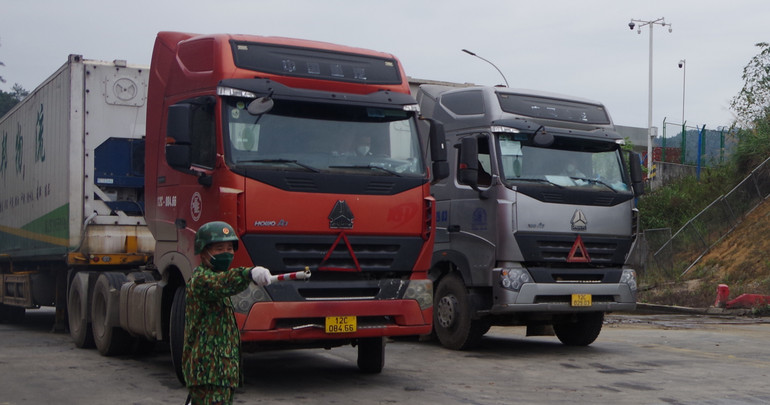 Lực lượng biên phòng cửa khẩu quốc tế Hữu Nghị hướng dẫn phân luồng xe chở hàng hóa vào khu vực chờ xuất khẩu.