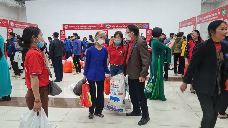 Cán bộ Hội Chữ thập đỏ tỉnh phát quà cho người nghèo.