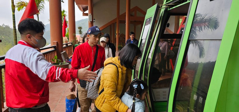 Các du khách được nhân viên hướng dẫn đi cáp treo lên chùa Ngọa Vân.