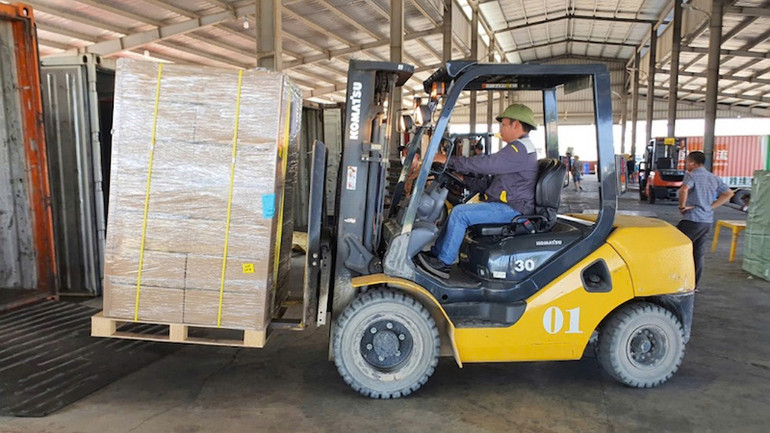 Bốc xếp hàng hóa nhập khẩu tại bãi kiểm hàng hóa Cầu Bắc Luân II, Móng Cái.