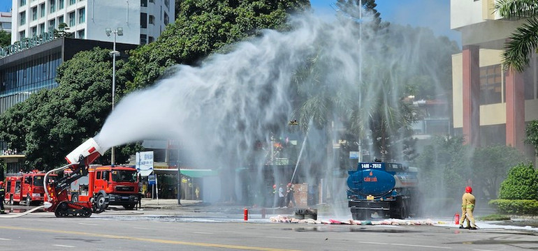 Lực lượng chức năng triển khai dập tắt vụ cháy nổ do xe chở xăng đâm vào xe chở hóa chất.