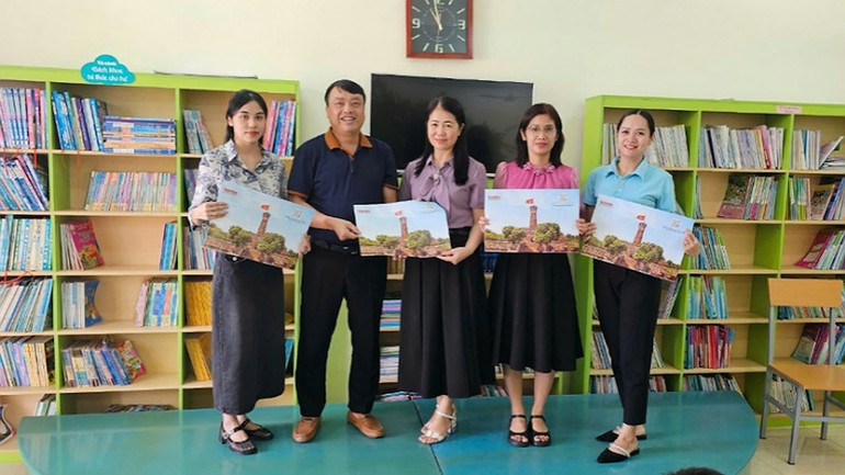 Đại diện Văn phòng Báo Nhân Dân tại tỉnh Quảng Ninh tặng ấn phẩm đặc biệt "Cột cờ Hà Nội" cho Trường tiểu học thị trấn Đầm Hà, Quảng Ninh.