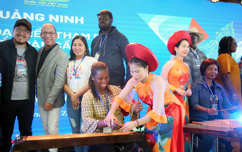 Các đại biểu quốc tế thích thú với các loại nhạc cụ dân tộc của Việt Nam. (Ảnh: Trung tâm truyền thông Quảng Ninh)