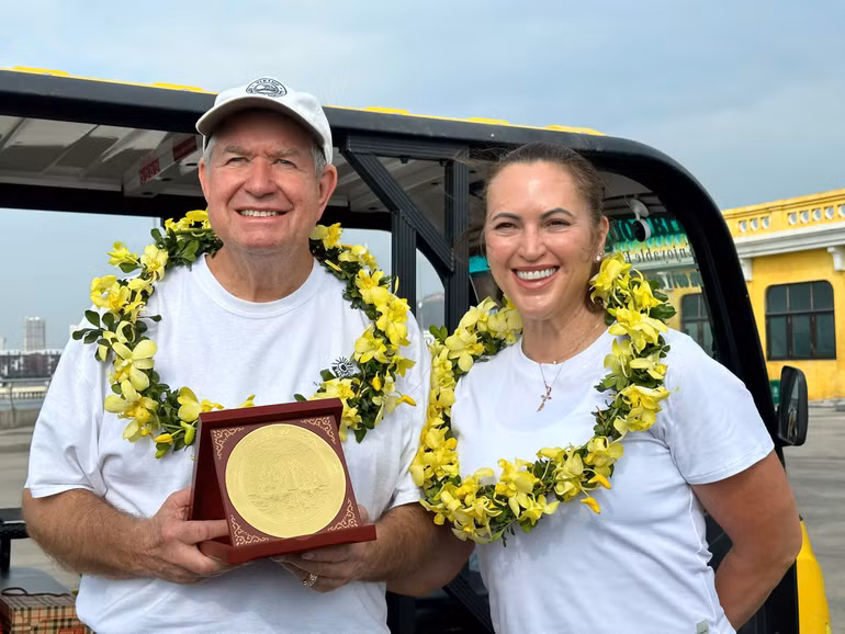 Vị khách quốc tế thứ 3 triệu Tina Bogle cùng chồng nhận hoa và quà lưu niệm của Ủy ban nhân dân tỉnh Quảng Ninh khi đến Hạ Long.