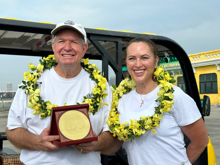 Vị khách quốc tế thứ 3 triệu Tina Bogle cùng chồng nhận hoa và quà lưu niệm của Ủy ban nhân dân tỉnh Quảng Ninh khi đến Hạ Long.