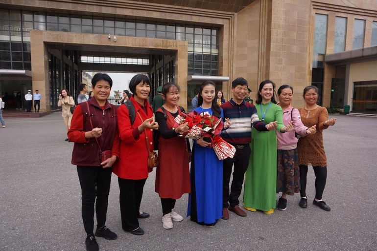 Du khách được chào đón và vui mừng chụp ảnh lưu niệm sau khi nhập cảnh qua Cửa khẩu quốc tế Móng Cái, Quảng Ninh.