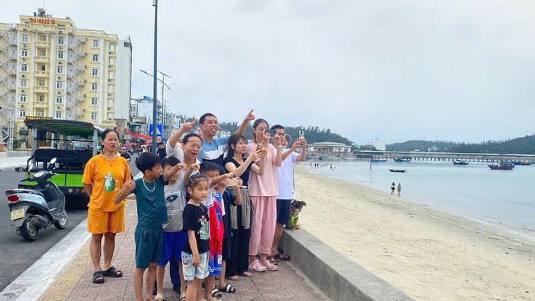 Đông đảo người dân và du khách thích thú chụp ảnh ghi lại màn trình diễn tuyệt vời này.