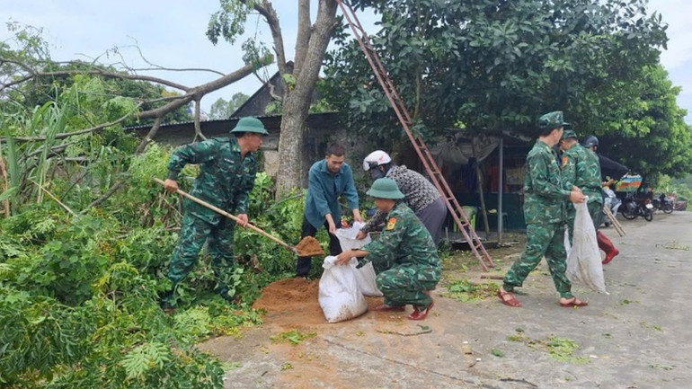 Cán bộ, chiến sĩ Đồn Biên phòng Cửa khẩu cảng Vạn Gia giúp người dân phòng, chống bão số 3.