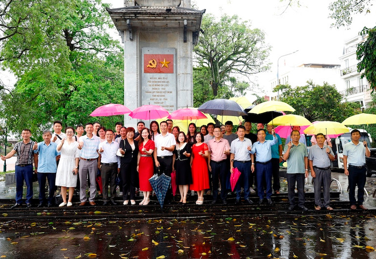 Đại biểu của 2 địa phương chụp ảnh lưu niệm tại Di tích Biểu tượng nơi thành lập Chi bộ Đảng cộng sản Việt Nam đầu tiên của huyện Hải Ninh (Tiền thân của Đảng bộ thành phố Móng Cái ngày nay).