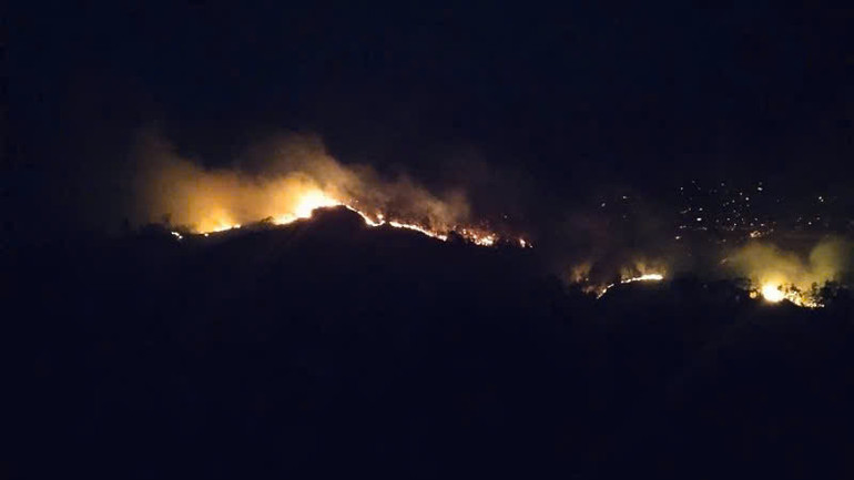 Lửa lan gây cháy trên khu vực đỉnh núi nên khó khăn cho các lực lượng chức năng và người dân tham gia dập lửa. (Ảnh người dân cung cấp)