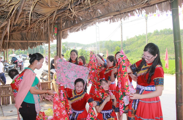 Du khách tham quan mua sắm trang phục người Dao tại chợ phiên Ba Nhất, xã Quảng An.