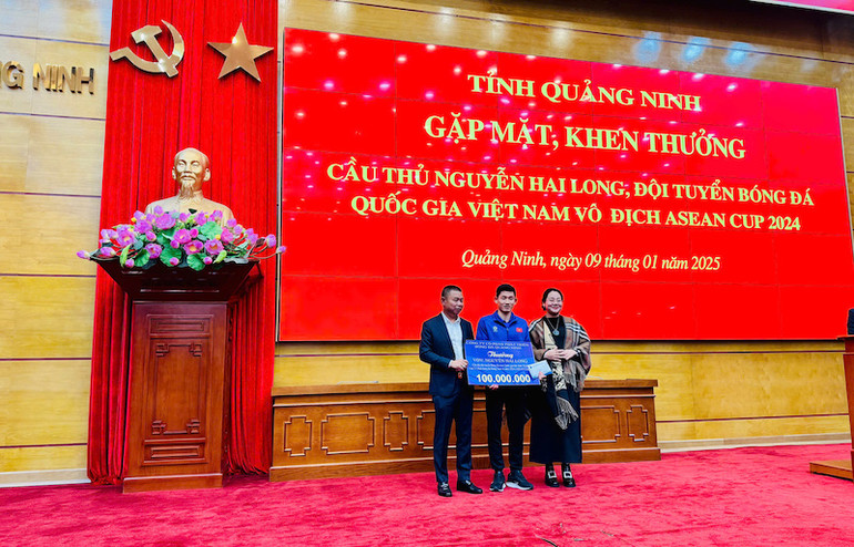 Đại diện lãnh đạo Câu lạc bộ Bóng đá Quảng Ninh thưởng 100 triệu đồng cho cầu thủ Nguyễn Hai Long.