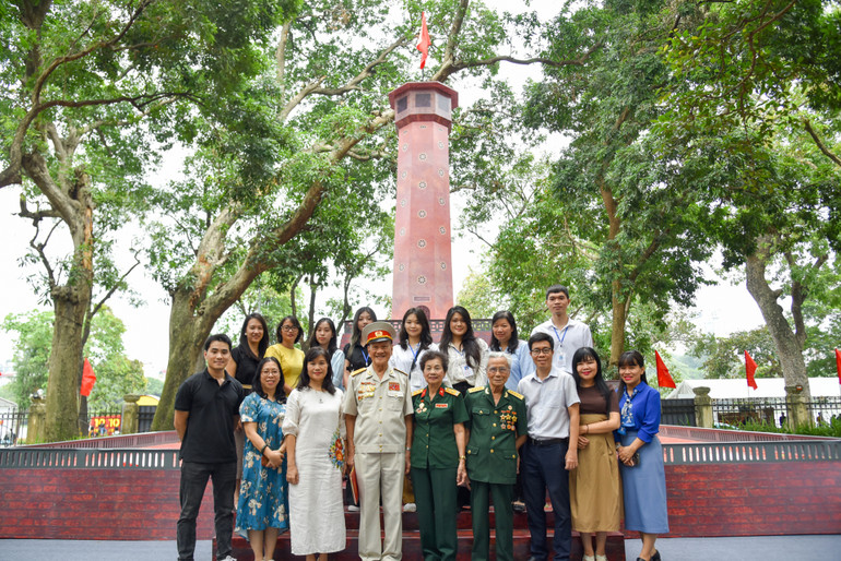 Các nhân chứng lịch sử dự giao lưu trực tuyến chụp ảnh lưu niệm cùng phóng viên Báo Nhân Dân tại Triển lãm tương tác Cột cờ Hà Nội.