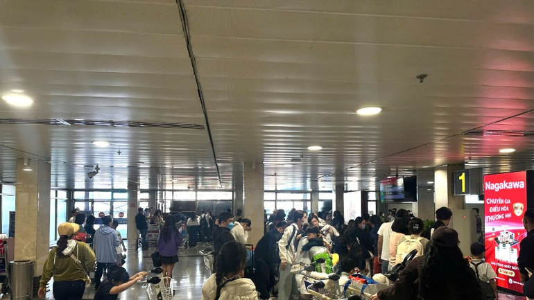 Trong ngày 2/2, có 863 chuyến bay cất và hạ cánh tại sân bay Tân Sơn Nhất. Hành khách chờ lấy hành lý tại sân bay. (Ảnh: QUÝ HIỀN)