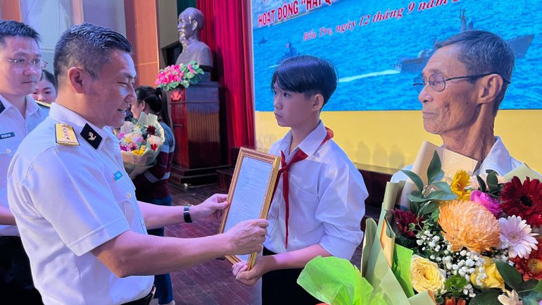 Đại tá Bùi Văn Quỳ, Phó Tổng Giám đốc Tổng Công ty Tân Cảng Sài Gòn trao quyết định nhận đỡ đầu cho con em ngư dân.