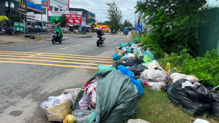 Đường vào trung tâm huyện Ba Tri rác chất thành đống hai bên lề đường.