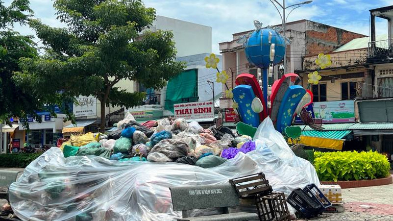Tại công viên Ba Mươi Tháng Tư (thị trấn Ba Tri), người dân phải thuê nhân công gom rác lại thành đống rồi che bằng tấm ny-lông để giảm mùi hôi và ruồi.