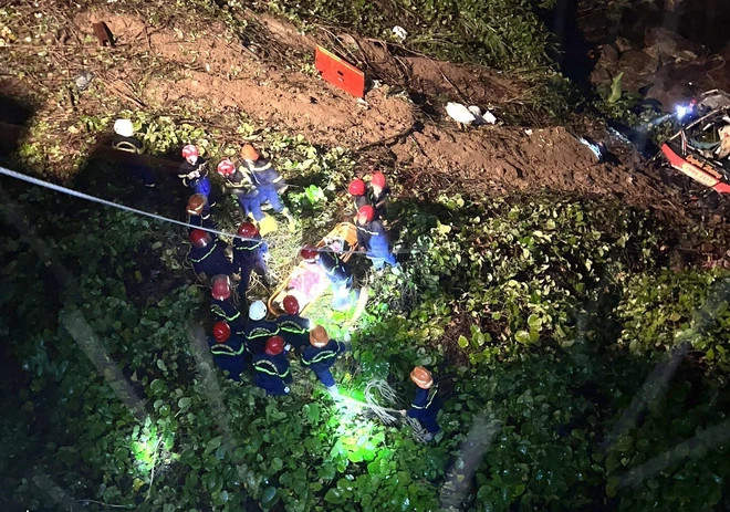 Lực lượng cứu hộ phải ròng dây để đưa người bị nạn lên khỏi vực. (Ảnh: TTXVN)