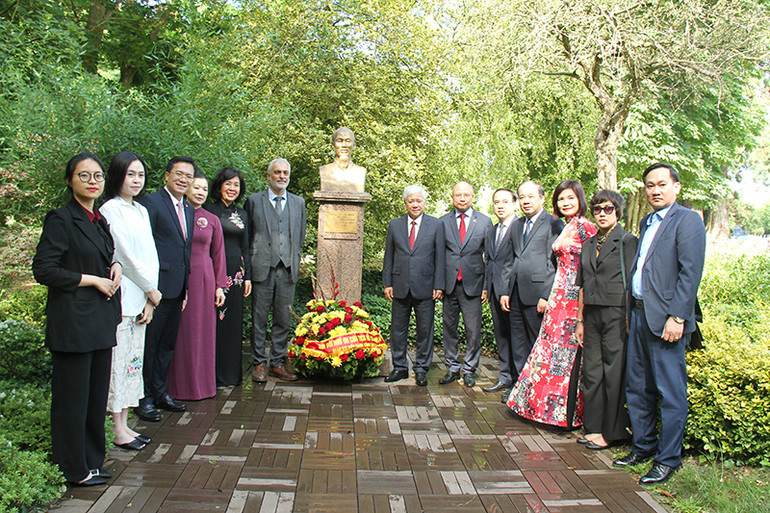 Các đại biểu chụp ảnh lưu niệm tại tượng Chủ tịch Hồ Chí Minh ở Công viên Montreau. (Ảnh: MINH DUY)