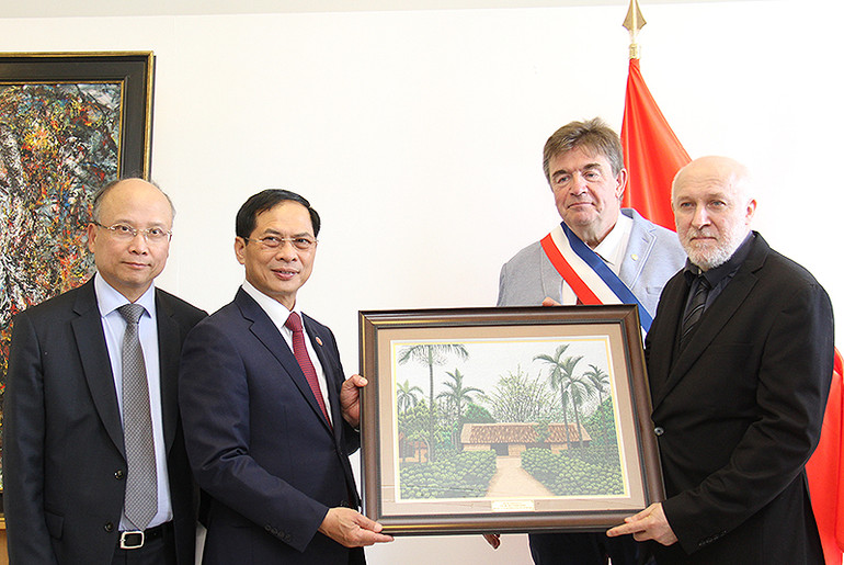 Bộ trưởng Bùi Thanh Sơn tặng bức tranh thêu "Nhà của gia đình Chủ tịch Hồ Chí Minh" cho ông Eric Lafon, Giám đốc Bảo tàng Lịch sử sống. (Ảnh: Khải Hoàn)