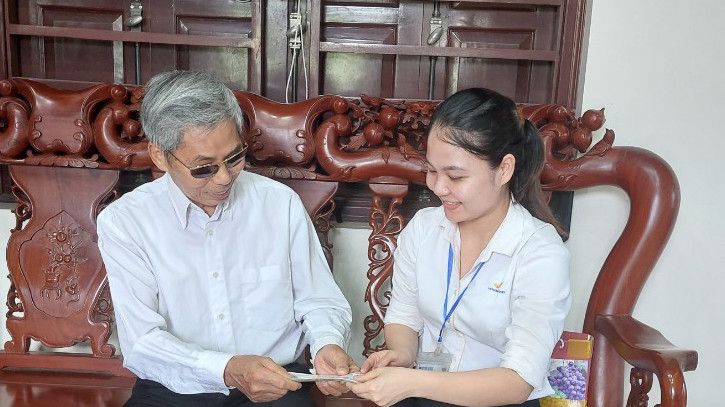 Ông Hoàng Văn Tít, thôn Hùng Vĩ, xã Đồng Văn, huyện Yên Lạc, tỉnh Vĩnh Phúc, nhận tiền lương hưu do nhân viên Điểm bưu điện văn hóa xã Đồng Văn chi trả tại nhà. (Ảnh: Vietnam Post)