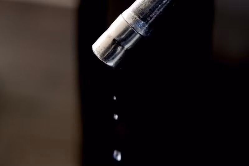 Xăng nhỏ giọt từ vòi bơm tại trạm xăng ở London, Anh. (Ảnh: THX/TTXVN)