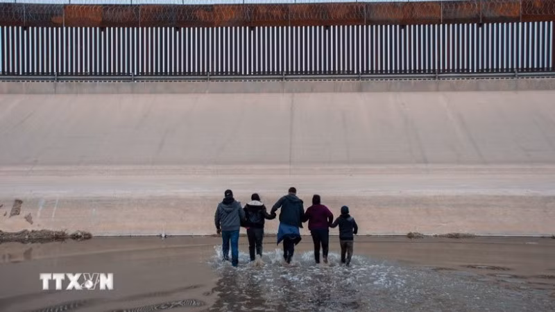 Người di cư vượt sông Rio Bravo ở biên giới Mỹ-Mexico. (Ảnh: THX/TTXVN)