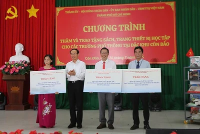Đồng chí Nguyễn Văn Nên, Ủy viên Bộ Chính trị, Bí thư Thành ủy Thành phố Hồ Chí Minh trao bảng tượng trưng tặng sách và thiết bị học tập cho 3 trường tại Côn Đảo (Ảnh Ban tổ chức).