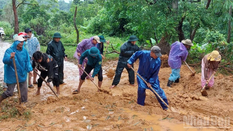 Bộ đội Biên phòng tỉnh cùng người dân dọn dẹp bùn đất trên các tuyến đường sau mưa lũ. 
