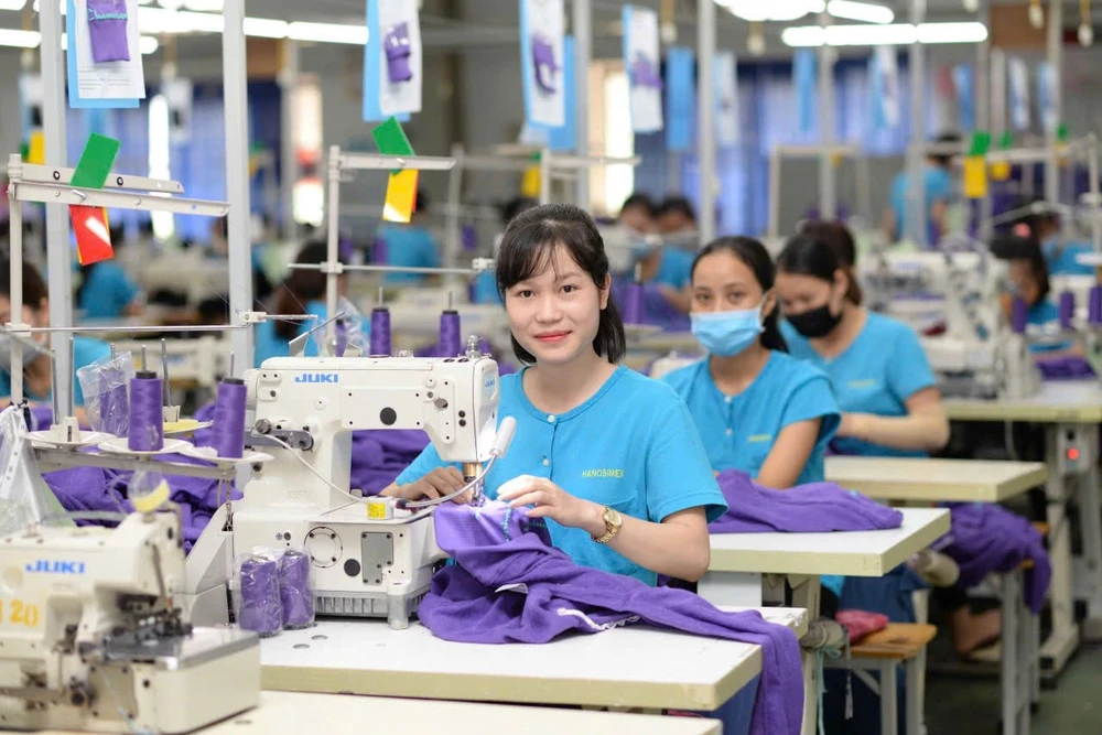 Công nhân nữ làm việc hứng khởi tại cơ sở sản xuất của Tổng công ty Cổ phần Dệt may Hà Nội (Hanosimex).