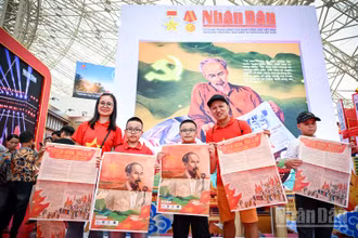 Niềm vui của một gia đình nhỏ khi xếp hàng và nhận được phụ san đặc biệt Báo Nhân Dân. Ảnh: THÀNH ĐẠT