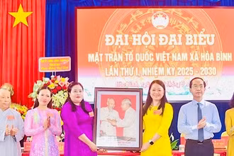 Đồng chí Hồ Thanh Thủy, Phó Bí thư Tỉnh ủy Cà Mau, trao tặng ảnh Bác Hồ và Bác Tôn, chúc mừng Đại hội Ủy ban Mặt trận Tổ quốc Việt Nam xã Hòa Bình. 