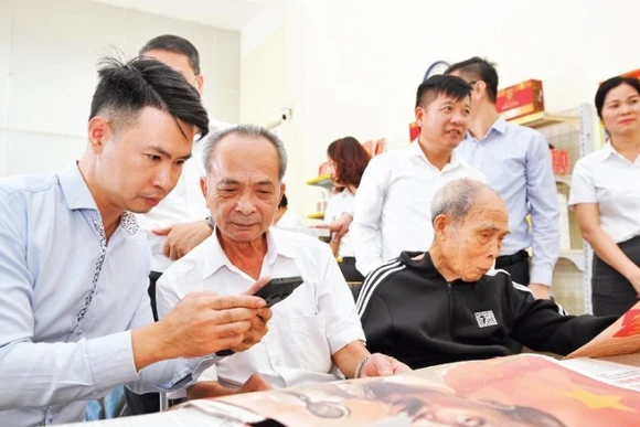 Người dân tìm hiểu phụ trương dự thảo các văn kiện trình đại hội XIV của Đảng tại điểm bưu điện văn hóa xã Dạ Trạch, tỉnh Hưng Yên. (Ảnh: THẾ ĐẠI)