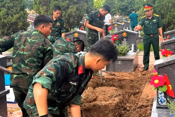 Các đơn vị thực hiện khai quật, lấy mẫu hài cốt liệt sĩ tại Nghĩa trang liệt sĩ Nhổn. (Ảnh: Mai Hoa)