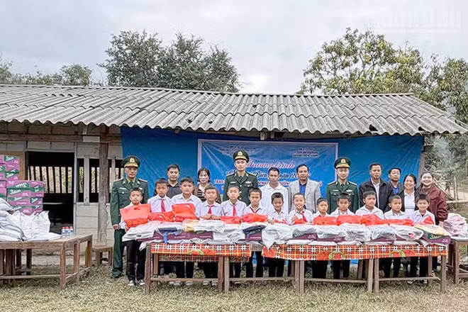 Cán bộ, chiến sĩ Đồn Biên phòng Cửa khẩu Chiềng Khương phối hợp đoàn thiện nguyện trao tặng quà cho học sinh trường tiểu học Huoicu, huyện MuongEt, tỉnh Huaphanh, nước bạn Lào.