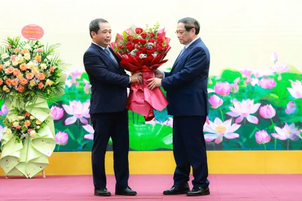 Thủ tướng Phạm Minh Chính tặng hoa chúc mừng quyền Bộ trưởng Nông nghiệp và Môi trường Trần Đức Thắng. (Ảnh: TRẦN HẢI)