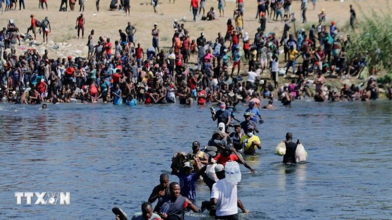 Người di cư vượt sông Rio Bravo từ Mexico để vào Mỹ. (Ảnh: THX/TTXVN)