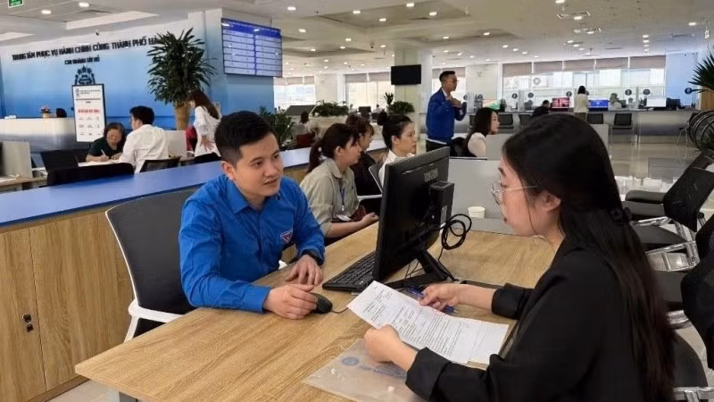 Thanh niên quận Tây Hồ hỗ trợ người dân sử dụng công nghệ số. (Ảnh: ĐĂNG ANH)