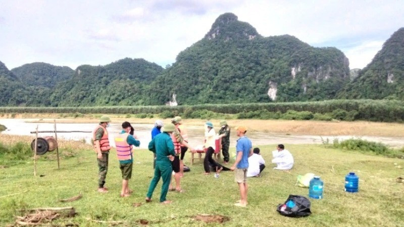 Lực lượng chức năng và gia đình tìm thấy thi thể 1 phụ nữ bị lũ cuốn ở xã Tân Hóa.