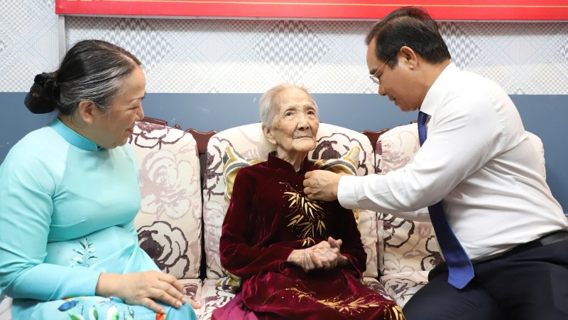 Chủ tịch Ủy ban nhân dân Thành phố Hồ Chí Minh Nguyễn Văn Được trao Huy hiệu 80 năm tuổi Đảng cho đảng viên Trần Thị Kim Anh.