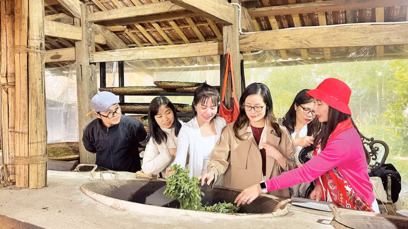 Du khách trải nghiệm sao trà bằng chảo gang.