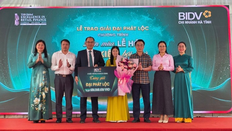 Đại diện lãnh đạo Ngân hàng Nhà nước Việt Nam khu vực 8, BIDV Hà Tĩnh, chính quyền địa phương tặng hoa chúc mừng khách hàng may mắn.