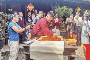 Nghệ nhân Nguyễn Công Đạt thực hiện in liễn làng Chuồn trong không gian Ngự Hà Viên, Huế. (Ảnh: MẠNH HÀO)